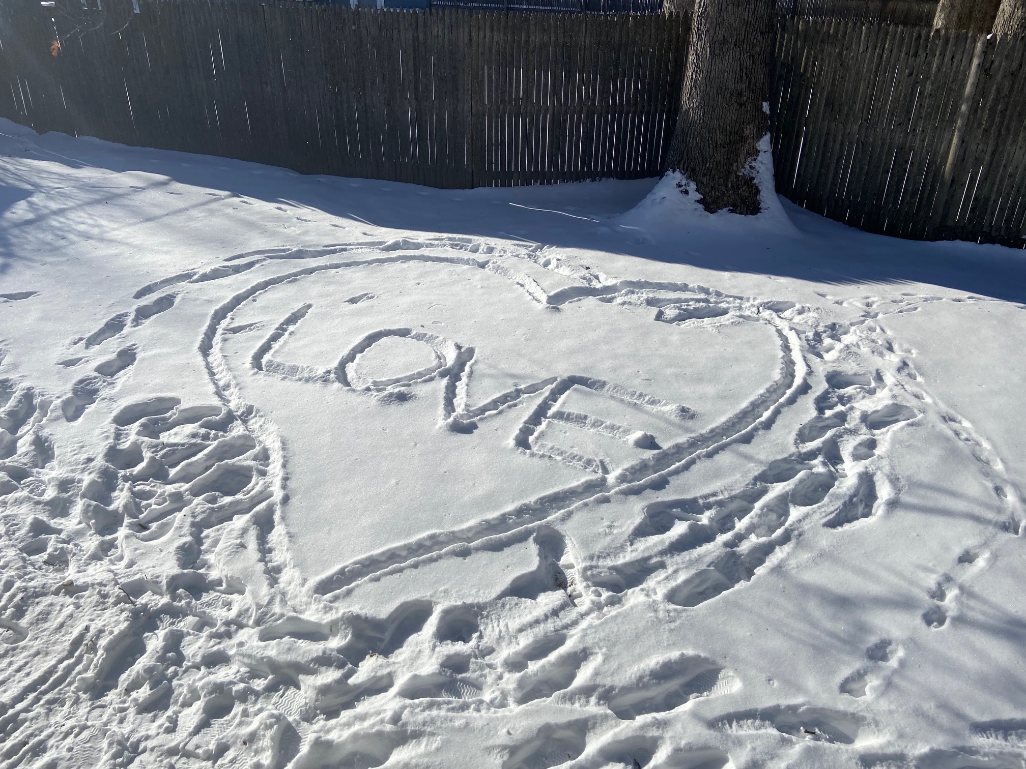 雪の上に描かれた大きなハートと「LOVE」の文字