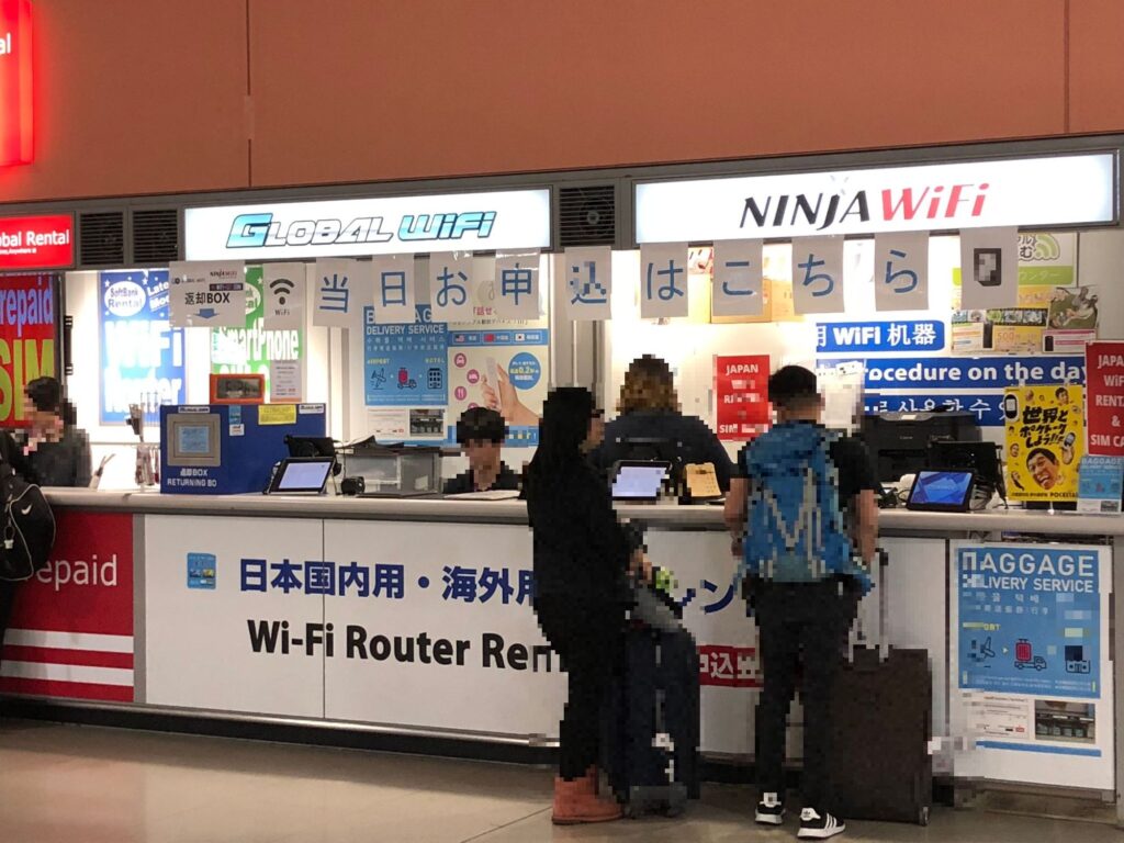 関西国際空港のWiFiレンタルカウンターで手続きを行う利用者たち