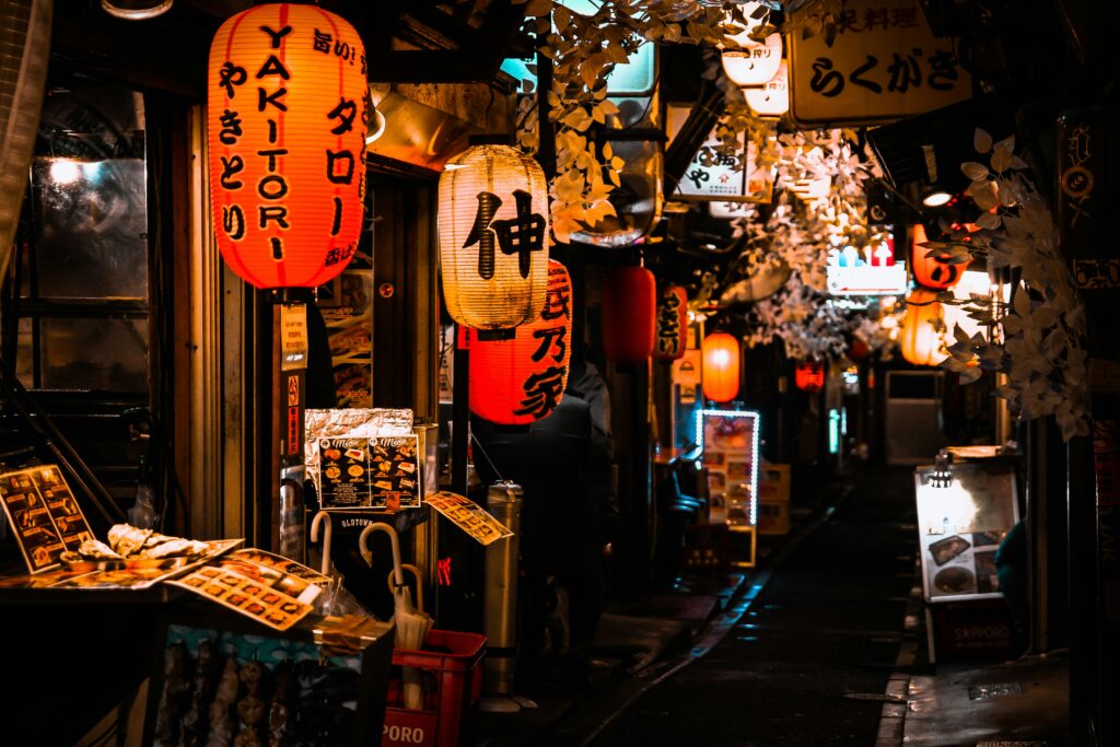 赤ちょうちんが並ぶ日本の居酒屋街の夜の風景。飲食店での優待特典のイメージ。