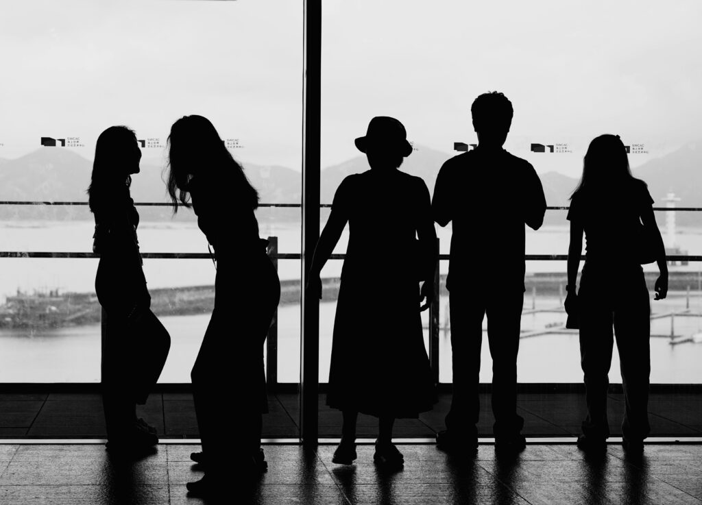 空港で佇む旅行者たちのシルエット