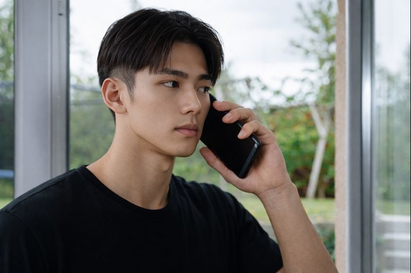 電話で保険会社とやりとりをしている若い男性の写真